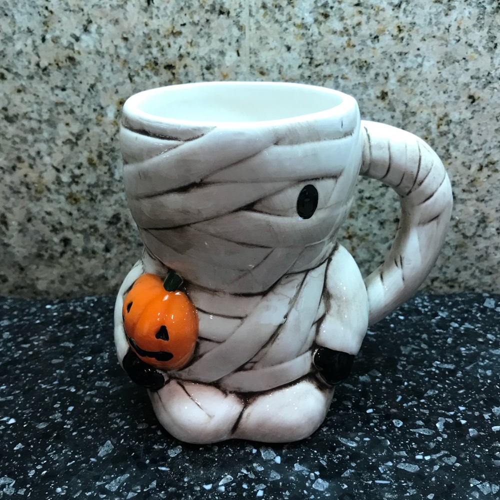 Mummy mug holding a pumpkin